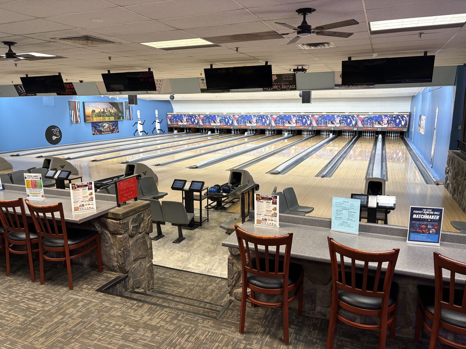 View from the seating area down the lanes, with TVs and ball returns